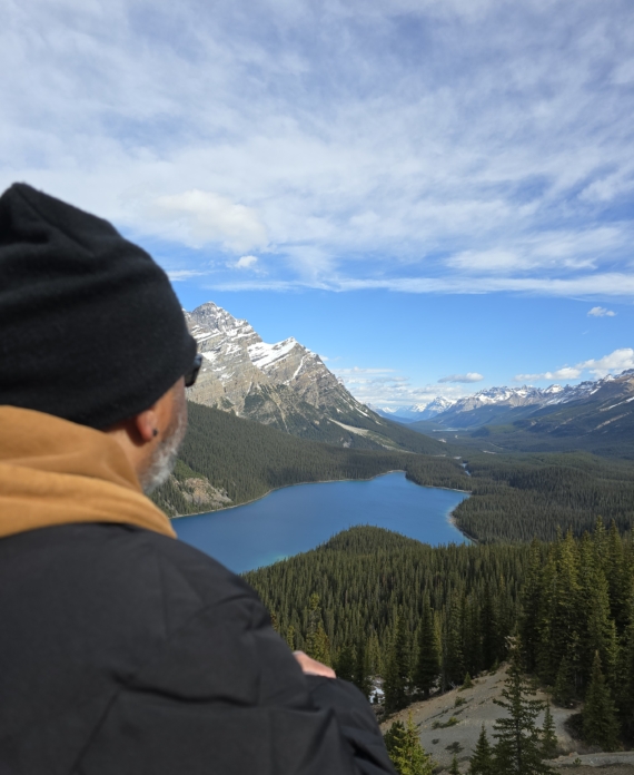 Drone Pilot looking out over a beautiful lake with a mountain backdrop